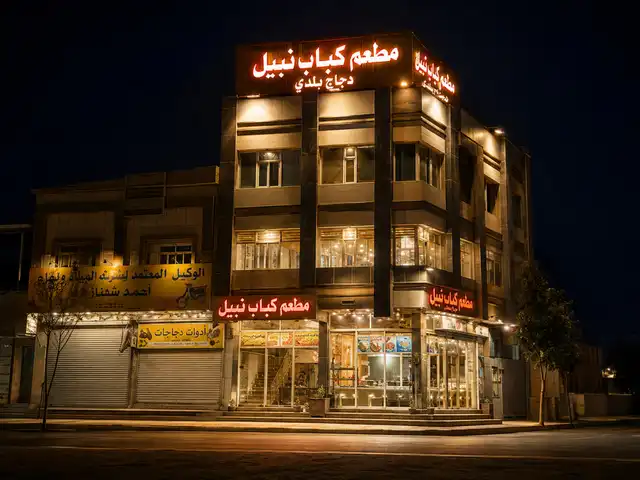 مبنى فرع حي رمضان مضاء ليلًا بلافتات حمراء